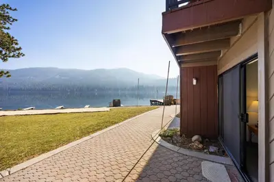 a building with a walkway next to a body of water at Cozy King Studio w/Lake View #145 at Donner Lake Village in Truckee