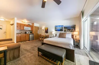a hotel room with a bed and a kitchen at Cozy Studio w/Kitchenette and Balcony #212 at Donner Lake Village in Truckee