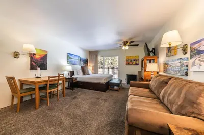 a living room with a couch and a bed and a table at Cozy Studio w/Kitchenette and Balcony #212 at Donner Lake Village in Truckee