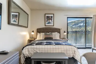 a bedroom with a bed and a large window at Beautiful Deluxe Studio w/Lake View #245 at Donner Lake Village in Truckee