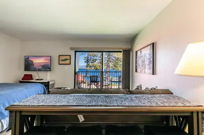 a bedroom with a bed and a balcony at Striking Studio w/Lake View #244 at Donner Lake Village in Truckee