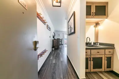 a kitchen with wood floors and a hallway with a sink at Striking King Studio w/Partial Lake View #242 at Donner Lake Village in Truckee