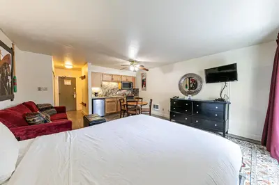 a bedroom with a white bed and a living room at Charming Queen Studio Deluxe w/Balcony #233 at Donner Lake Village in Truckee