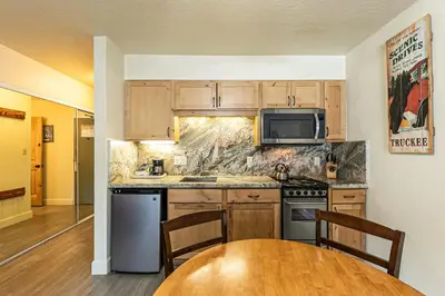 a kitchen with wooden cabinets and a wooden table at Charming Queen Studio Deluxe w/Balcony #233 at Donner Lake Village in Truckee
