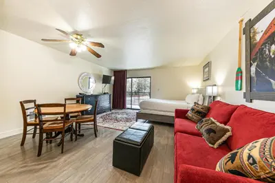 a living room with a red couch and a table at Charming Queen Studio Deluxe w/Balcony #233 at Donner Lake Village in Truckee