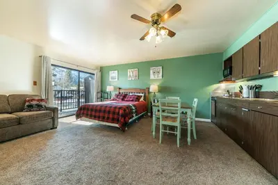 a bedroom with a bed and a table and a kitchen at Cozy Studio w/Partial Lake view #224 at Donner Lake Village in Truckee