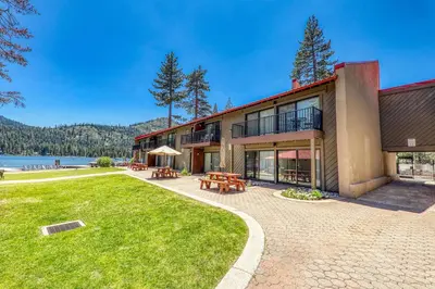an exterior view of a building with a lawn and tables at Cozy Studio w/Partial Lake view #224 at Donner Lake Village in Truckee