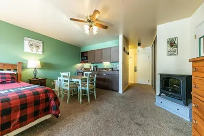 a bedroom with a bed and a kitchen with a table at Cozy Studio w/Partial Lake view #224 at Donner Lake Village in Truckee
