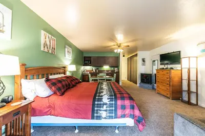 a bedroom with a large bed and a kitchen at Cozy Studio w/Partial Lake view #224 at Donner Lake Village in Truckee