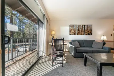 a living room with a couch and a balcony at Spacious 1BR Condo w/Partial Lake View #222 at Donner Lake Village in Truckee