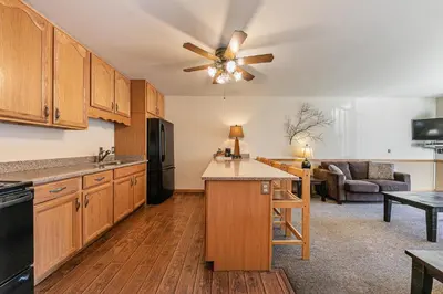 a kitchen with wooden cabinets and a ceiling fan at Spacious 1BR Condo w/Partial Lake View #222 at Donner Lake Village in Truckee