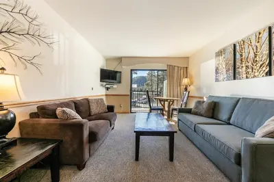 a living room with a couch and a table at Spacious 1BR Condo w/Partial Lake View #222 at Donner Lake Village in Truckee