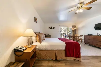 a bedroom with a bed and a table with a lamp at Studio w/Kitchen 2nd Floor #213 at Donner Lake Village in Truckee