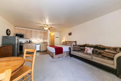 a large bedroom with a bed and a kitchen at Studio w/Kitchen 2nd Floor #213 at Donner Lake Village in Truckee