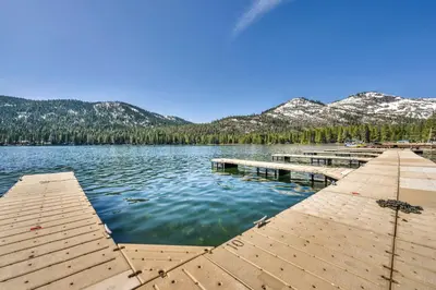 a dock on a lake with mountains in the background at Spacious 1BR Condo w/ Lake View #136 at Donner Lake Village in Truckee
