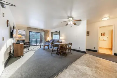 a living room with a ceiling fan and a table and chairs at Spacious 1BR Condo w/ Lake View #136 at Donner Lake Village in Truckee