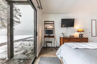 a bedroom with a bed and a tv and a window at Inviting King Deluxe 1 BR Condo W/Lake view #141 at Donner Lake Village in Truckee