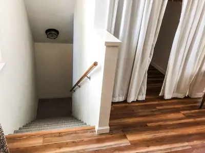 a stairway with white curtains and wooden floors at Twain Harte retreat w/ lake access, ski/Yosemite in Twain Harte