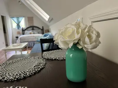 a green vase with a white flower on a table at Twain Harte retreat w/ lake access, ski/Yosemite in Twain Harte