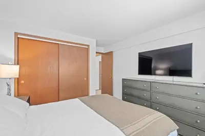 a bedroom with a bed and a dresser with a flat screen tv at Waves End Lakefront - 3BR Tahoe Vista w Private Sandy Beach, Walk to Town! in Tahoe Vista