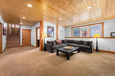 a living room with a couch and a table at Copperleaf Lodge by Tahoe Getaways - Updated 5BR Alpine Meadows Chalet w Private Hot Tub, Ski Shuttle! in Alpine Meadows