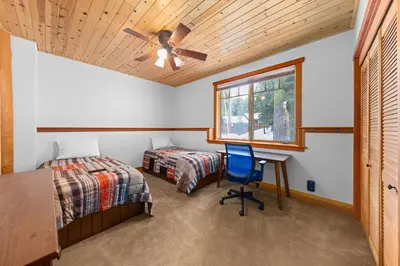 a bedroom with two beds and a ceiling fan at Copperleaf Lodge by Tahoe Getaways - Updated 5BR Alpine Meadows Chalet w Private Hot Tub, Ski Shuttle! in Alpine Meadows