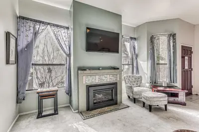 a living room with a fireplace and a tv at Spacious Downtown Fresno Townhome Walk to UCSF in Fresno