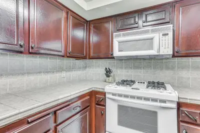 a kitchen with a stove and a microwave at Spacious Downtown Fresno Townhome Walk to UCSF in Fresno