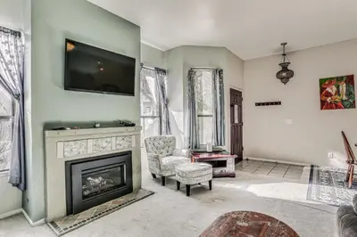 a living room with a fireplace and a tv at Spacious Downtown Fresno Townhome Walk to UCSF in Fresno