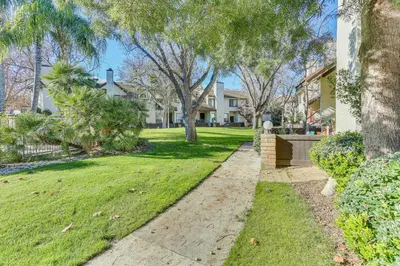 a walkway through a yard with trees and houses at Spacious Downtown Fresno Townhome Walk to UCSF in Fresno