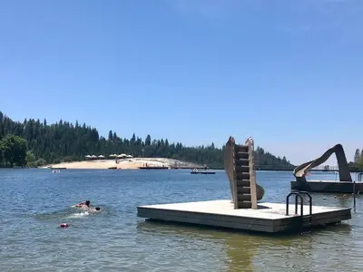 a person swimming in a lake with a playground at Read Haven 3 Bedroom, 1.5 Bath in Twain Harte