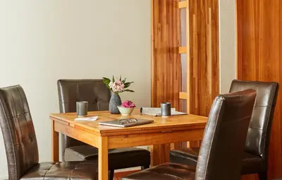 a wooden table with leather chairs and a vase of flowers at Palisades Tahoe Lodge Rentals Premium One Bedroom #321 in Olympic Valley