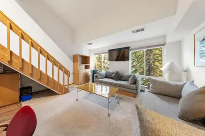 a living room with a couch and a table at Palisades Tahoe Lodge Rentals Studio Loft #308 in Olympic Valley
