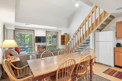 a kitchen and living room with a wooden table and chairs at Palisades Tahoe Lodge Rentals Studio Loft #306 in Olympic Valley