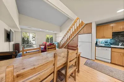 a kitchen with a wooden table in a room at Palisades Tahoe Lodge Rentals Studio Loft #315 in Olympic Valley
