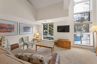 a living room with a couch and a tv at Palisades Tahoe Lodge Rentals Studio Loft #310 in Olympic Valley