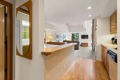 a kitchen with a counter and a living room at Palisades Tahoe Lodge Rentals Studio Loft #310 in Olympic Valley