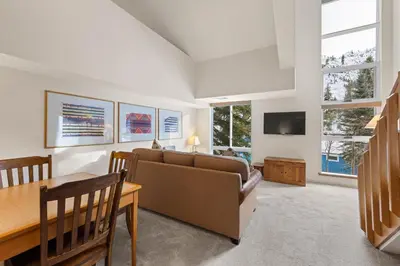 a living room with a couch and a table at Palisades Tahoe Lodge Rentals Studio Loft #310 in Olympic Valley