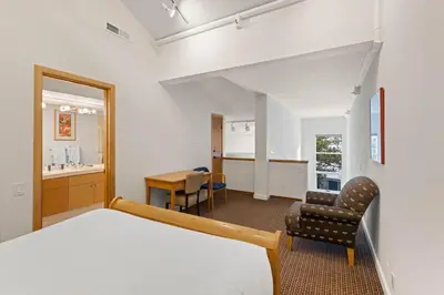 a bedroom with a bed and a chair and a desk at Palisades Tahoe Lodge Rentals Studio Loft #310 in Olympic Valley