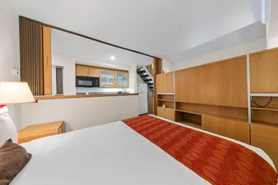 a bedroom with a large bed and a kitchen at Palisades Tahoe Lodge Rentals Studio Loft #317 in Olympic Valley