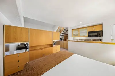 a bedroom with a bed and wooden cabinets at Palisades Tahoe Lodge Rentals Studio Loft #305 in Olympic Valley