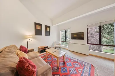a living room with a couch and a tv at Palisades Tahoe Lodge Rentals Studio Loft #345 in Olympic Valley