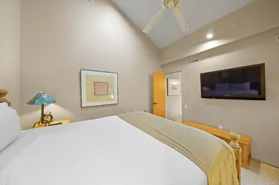 a bedroom with a white bed and a flat screen tv at Studio Loft #348 in Olympic Valley