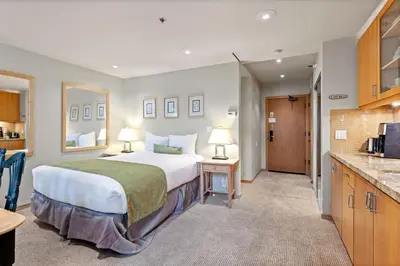 a hotel room with a large bed and a kitchen at Palisades Tahoe Lodge Rentals Studio Loft #349 in Olympic Valley