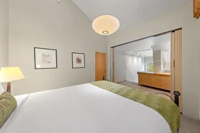 a bedroom with a large white bed and a mirror at Palisades Tahoe Lodge Rentals Studio Loft #349 in Olympic Valley