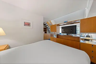 a bedroom with a white bed and a kitchen at Palisades Tahoe Lodge Rentals Studio Loft #314 in Olympic Valley