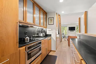 a kitchen with wooden cabinets and a stove top oven at Palisades Tahoe Lodge Rentals Premium Studio Loft #333 in Olympic Valley