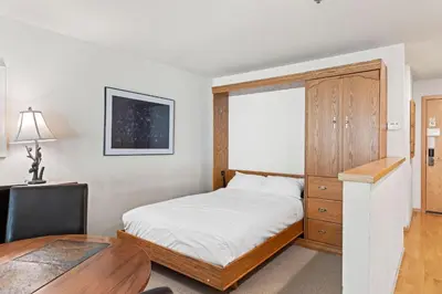 a bedroom with a bed and a desk and a window at Palisades Tahoe Lodge Rentals Studio Loft #353 in Olympic Valley