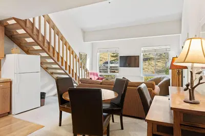 a kitchen and living room with a table and chairs at Palisades Tahoe Lodge Rentals Studio Loft #353 in Olympic Valley