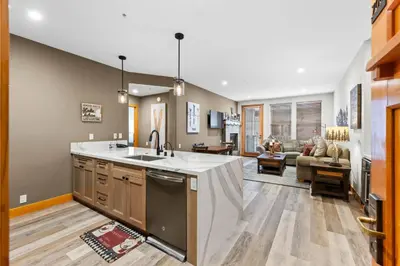 a kitchen with a sink and a living room at Palisades Tahoe Lodge Rentals Premium Two Bedroom #700 in Olympic Valley
